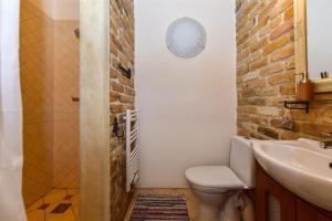 a bathroom with a toilet and a sink and a brick wall at Country Home in Ventspils