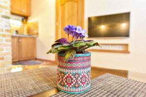 a vase with purple flowers in it on a table at Country Home in Ventspils