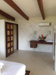 a bedroom with a bed and a table and a window at Casa Flor de Mar in Zipolite