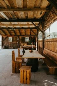 une table et des bancs en bois dans un bâtiment dans l'établissement RANČ JUREŠ, à Ljutomer