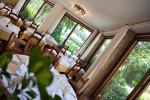 a dining room with tables and chairs and windows at Hotel Danila in Portoferraio