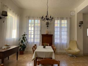 a dining room with a table and a chandelier at Les Merisiers B&B - Thorenc in Thorenc