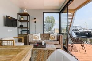 uma sala de estar com um sofá e uma mesa em Luxe Houseboat Skoft em Grou