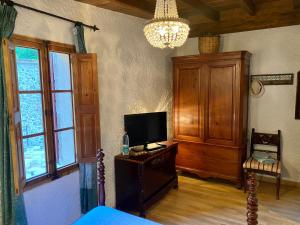 a living room with a tv and a bed and windows at Finca Ses Fontanelles in Andratx