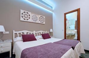 a bedroom with two beds and a sink and a mirror at Hostal Bruña Paseo del Prado in Madrid