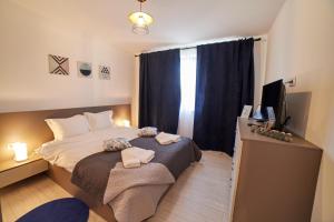 Dormitorio pequeño con cama y TV en Avram Iancu Apartments en Braşov