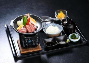 a tray of food with sushi and rice on it at Hotel Amandi in Nagasaki