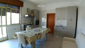 eine Küche mit einem Tisch und einigen Stühlen sowie einem Tisch und einer Küche in der Unterkunft Casa Maria in Manduria