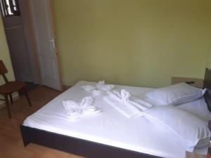 a bed with white sheets and white flowers on it at Delta ca Odinioara in Sulina
