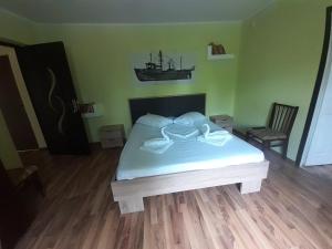 1 dormitorio con 1 cama con un barco en la pared en Delta ca Odinioara, en Sulina