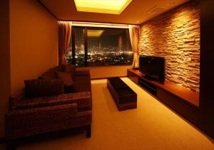 a living room with a couch and a large window at Hotel Amandi in Nagasaki