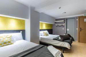 a hotel room with two beds and a hallway at Sun & Moon Hostel in Barcelona