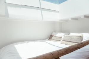 a bedroom with a bed with white sheets and pillows at MOOI Skylight in Mikonos