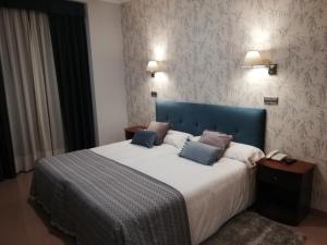 a hotel room with a bed and two nightstands at Hotel Las Moradas in Ávila