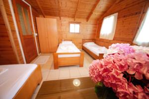 a room with two beds and pink flowers in it at Lodges Shen Nikolla in Dhërmi