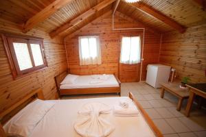 a room with two beds in a wooden cabin at Lodges Shen Nikolla in Dhërmi