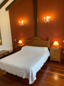 um quarto com uma cama branca e duas mesas de cabeceira em La Posada de Abanillas em Abanillas