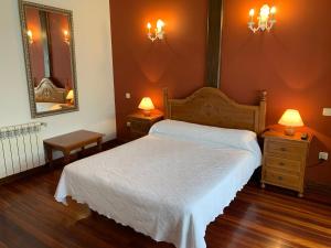 a bedroom with a white bed and two night stands at La Posada de Abanillas in Abanillas