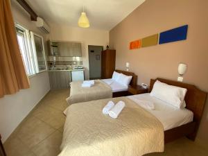 a hotel room with two beds and a kitchen at Maritsa's Rooms in Stavros +29 photos