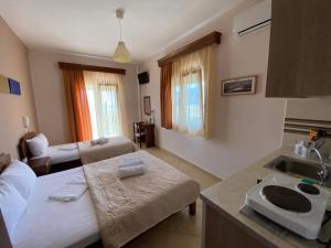 Maritsa's Rooms في ستافروس: غرفة مع مطبخ وغرفة معيشة