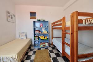 a bedroom with two bunk beds and a checkered floor at Villa Cala Trons in Lloret de Mar +12 photos
