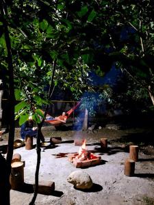 a fire pit in a park with people in a hammock at Hotel Alley in Martvili