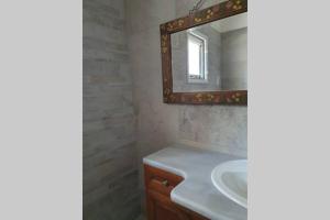 a bathroom with a sink and a mirror at Σγουρής (Sgouris) in Lefkimmi