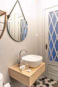 La salle de bains est pourvue d'un lavabo et d'un miroir. dans l'établissement Espinho Vintage - Alojamento de Charme, à Espinho