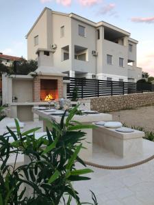 a house with a fire pit in front of it at Villa Bella with pool in Novalja