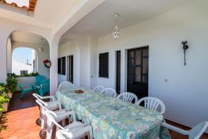 uma sala de jantar com uma mesa e cadeiras brancas em Casa Costa e Silva by Intiholidays em Boliqueime