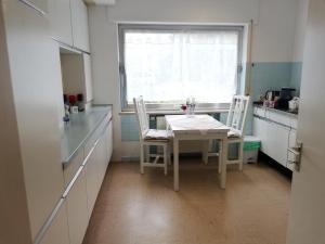 eine Küche mit einem Tisch und Stühlen sowie einem Fenster in der Unterkunft Villa Caroline in Pirmasens