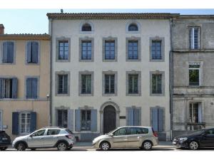 Dos coches aparcados delante de un gran edificio. en DOLCE VITA, en Carcassonne