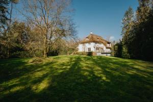 a large house on a grassy hill with a tree at De zandberg Vakantiewoning in Neerpelt