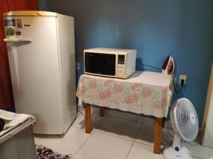 La cocina está equipada con microondas y nevera. en Cozy House Booking Indaiatuba, en Indaiatuba