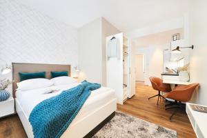 a bedroom with a bed with a blue blanket on it at ÜberFluss Serviced-Apartments in Bremen