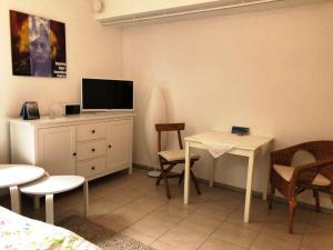 ein Wohnzimmer mit Fernseher und Tisch und Stühlen in der Unterkunft Ferienapartment am See mit Yogaraum und Kajak SUP Verleih in Heidesee