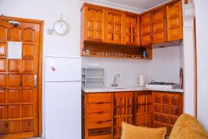kuchnia z drewnianymi szafkami i białą lodówką w obiekcie Villa Ali Ozalp w mieście Dalyan
