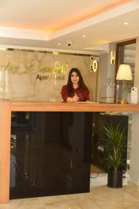 Eine Frau, die hinter einem Tresen in einem Raum steht. in der Unterkunft Pure Diamond Hotel in Antalya
