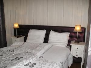um quarto com uma cama grande e 2 candeeiros nas mesas em 't Rond Bargie em Exloo