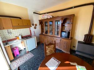a kitchen with a table and a stove and cabinets at Appartamenti NeMoZo Moretti in Ponzone