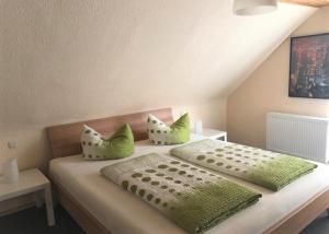 a bedroom with a bed with green pillows at FeWo Stubenhocker in Pleisweiler-Oberhofen