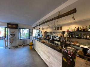 a large kitchen with a bar in a restaurant at Appartamenti NeMoZo Moretti in Ponzone