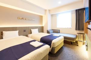 a hotel room with two beds and a window at hotel MONday Premium Ueno Okachimachi in Tokyo