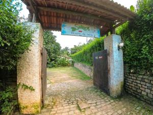 an entrance to a building with a gate and a sign at Saíra Recanto de Serra in Mulungu