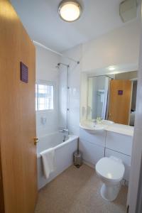 y baño con bañera, aseo y lavamanos. en Redwings Lodge Solihull en Solihull