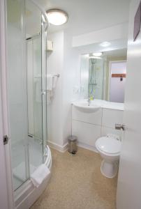 een badkamer met een douche, een toilet en een wastafel bij Redwings Lodge Solihull in Solihull