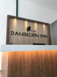 a sign for a dandelion inn on a wall at Dandelion Inn in Simpang Pulai