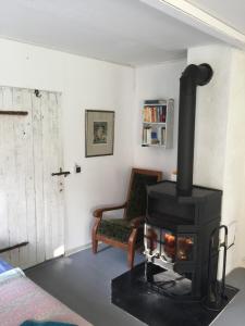 a living room with a stove and a chair at Appartement im alten Pferdestall in Salzhausen