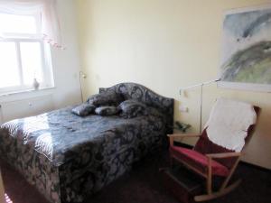 a bedroom with a bed and a chair and a window at Urlaubsdomizil Lengefeld in Lengefeld