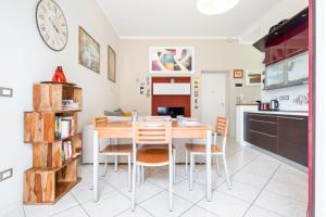 uma cozinha e sala de jantar com mesa e cadeiras em Giardino Vignoli Functional Apartment em Bolonha